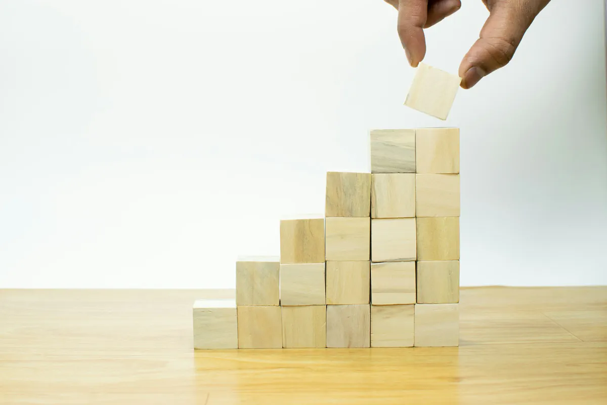 Main empilant des cubes en bois en escalier